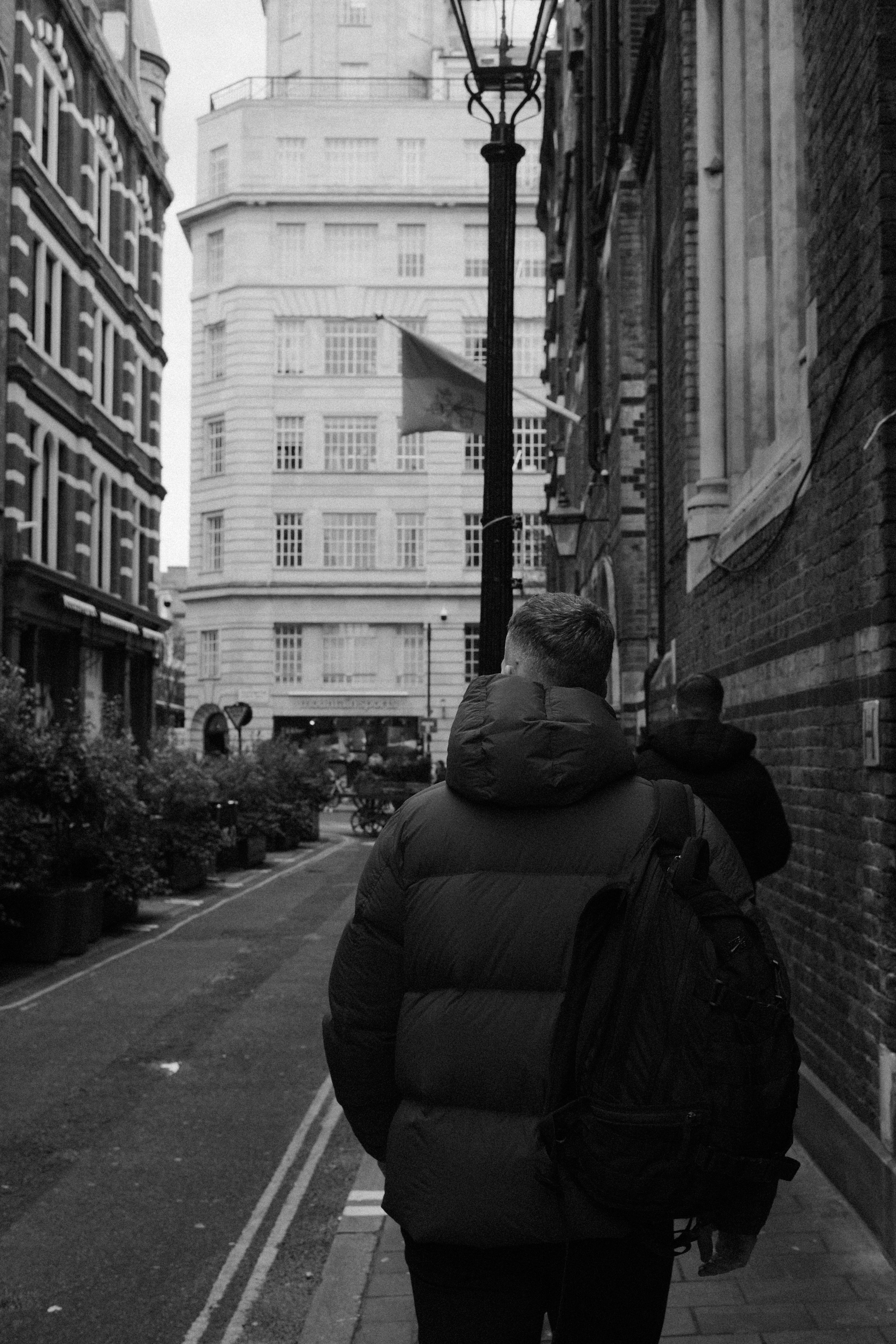 Man in Jacket on Sidewalk in Black and White · Free Stock Photo
