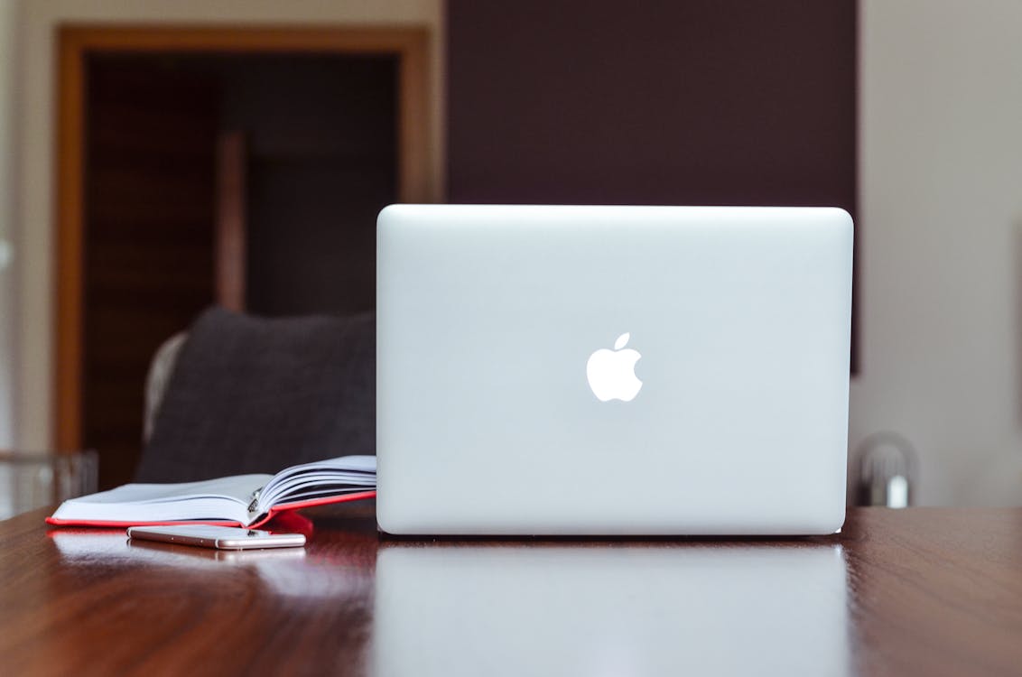 Gratis Macbook Air Cerca Del Libro Rojo Foto de stock