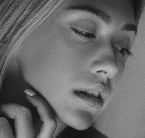 Free Artistic black and white close-up portrait capturing a young woman's thoughtful expression. Stock Photo