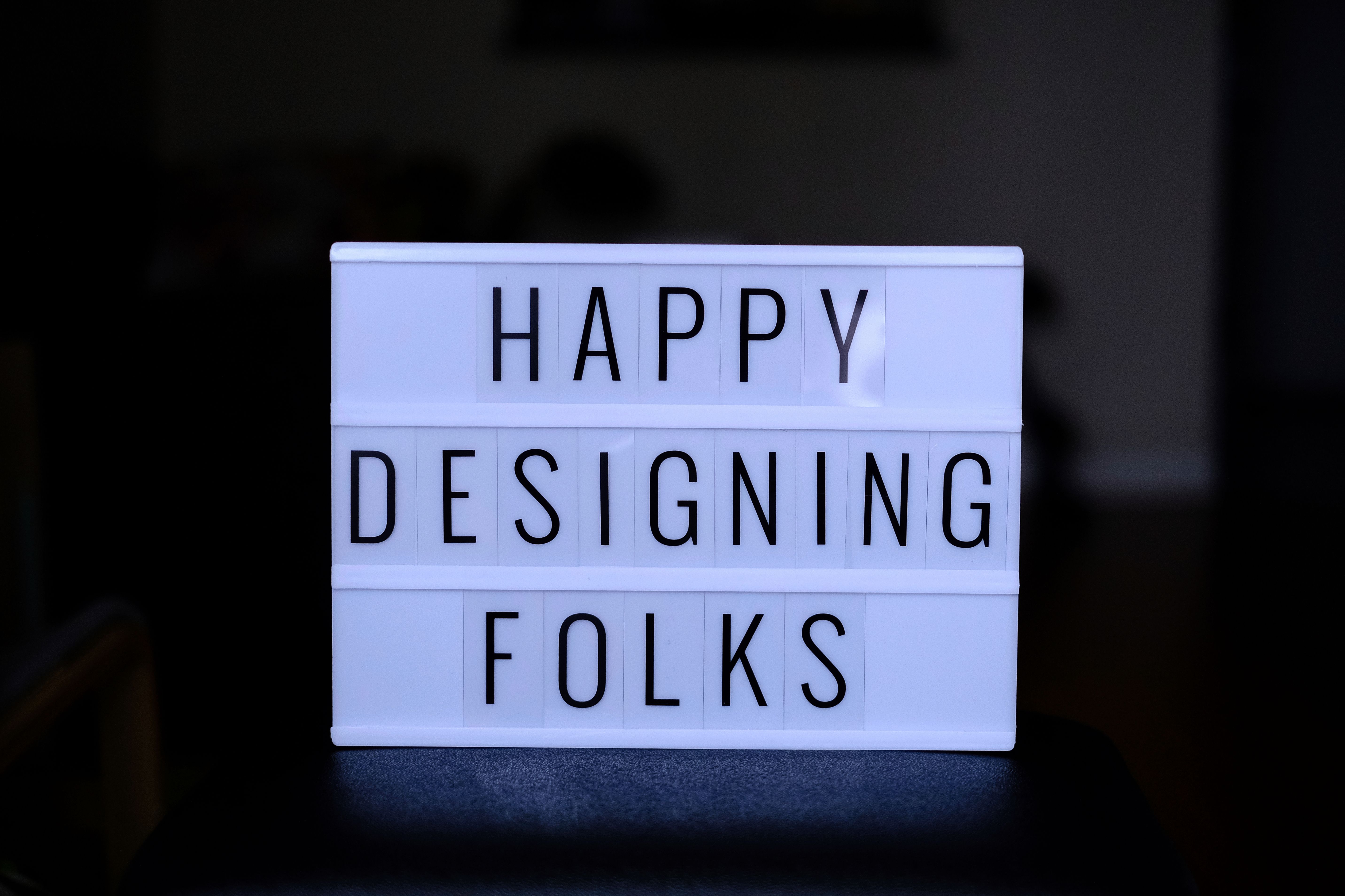 A white light box with the words happy designing folkFree Stock Photo