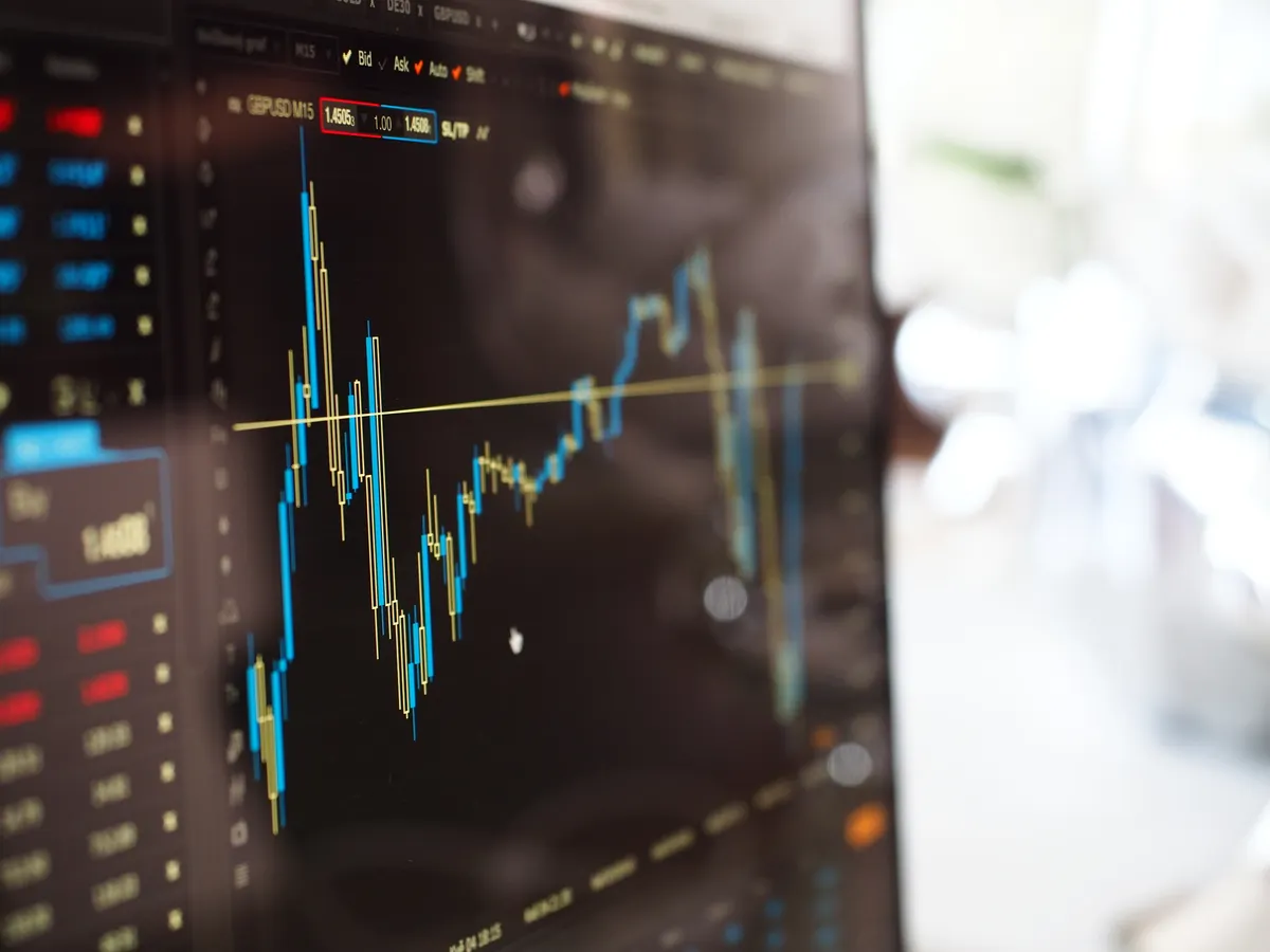 A close-up of a monitor displaying live financial trading data, representing the verification step where an alert becomes a filled Tradovate order.