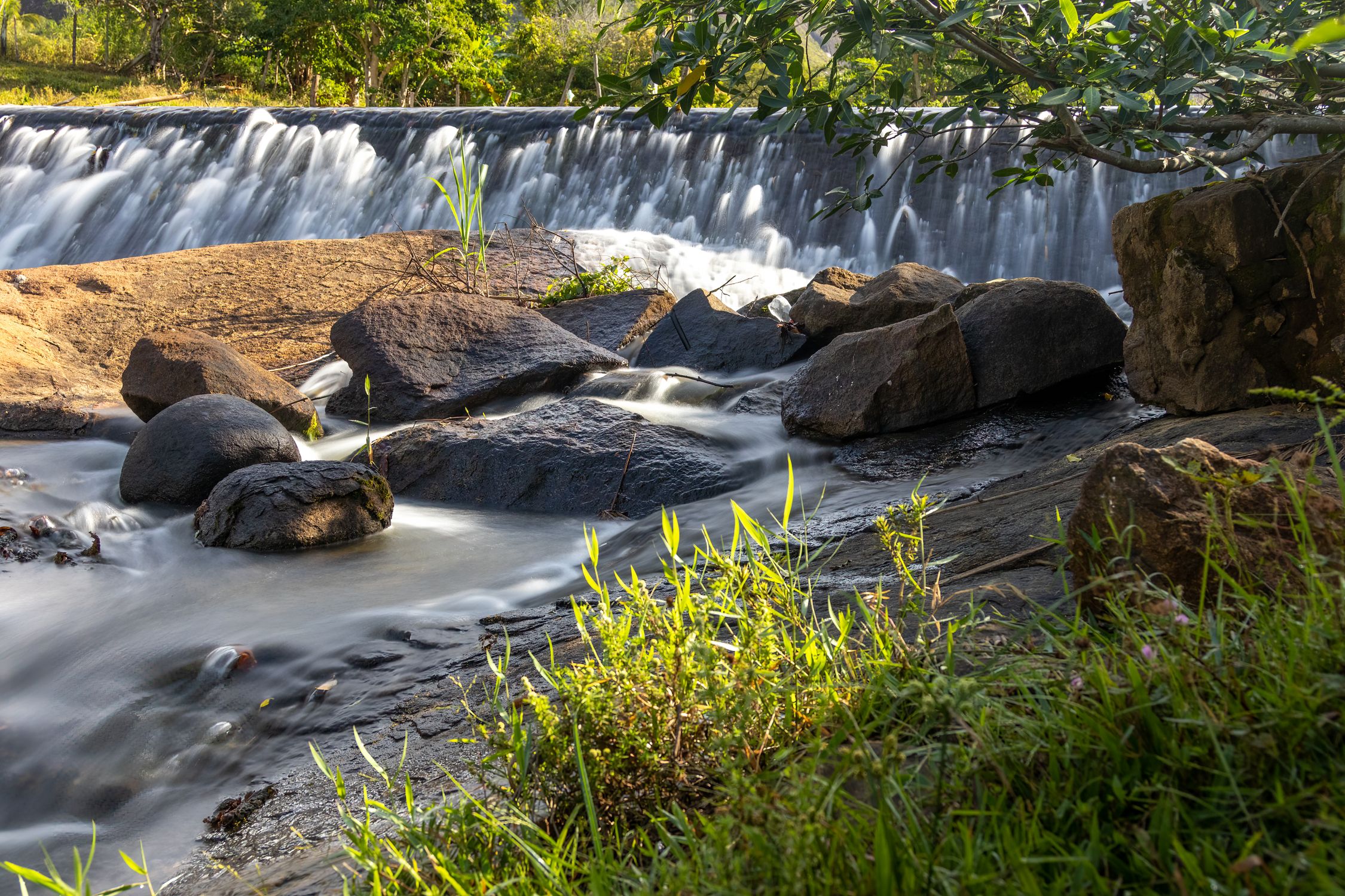 Rocks on a Riverbank with a View of the Waterfall · Free Stock Photo