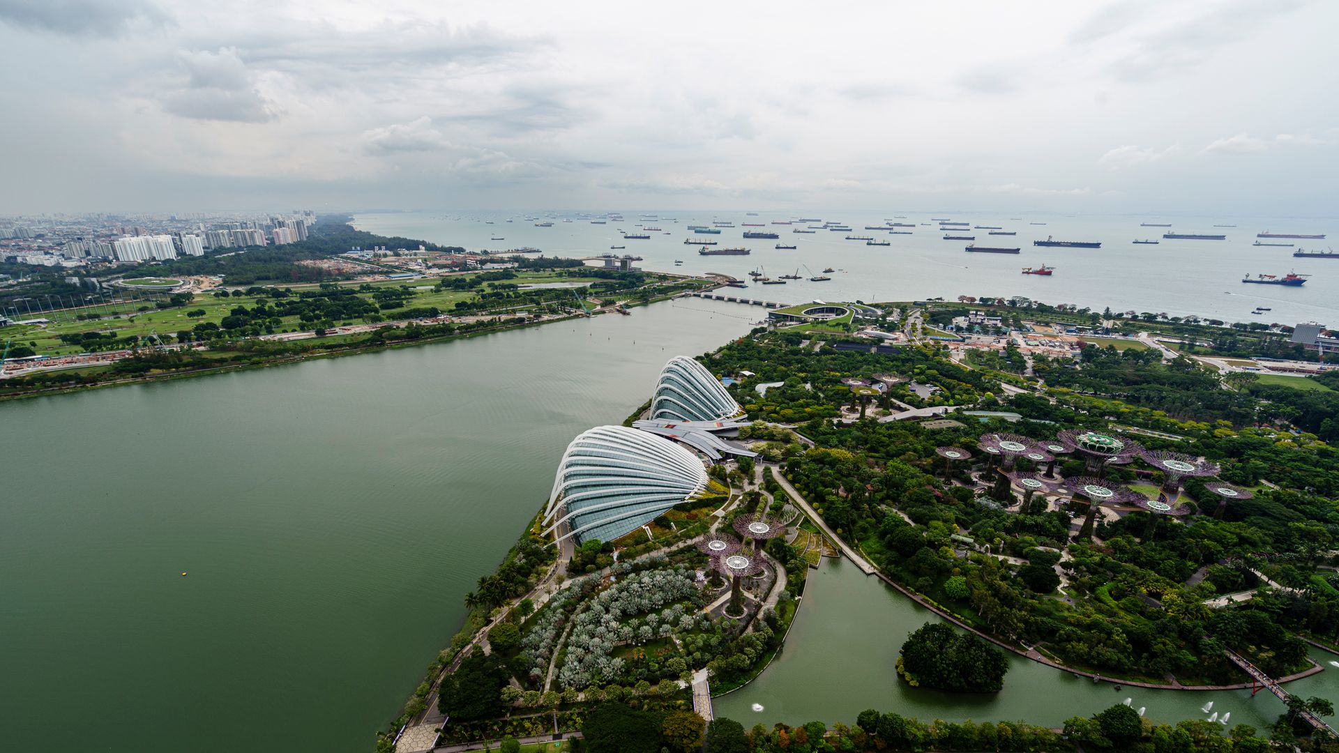 Aerial shot of Marina Bay with lush gardens and coastal waters, Singapore skyline.