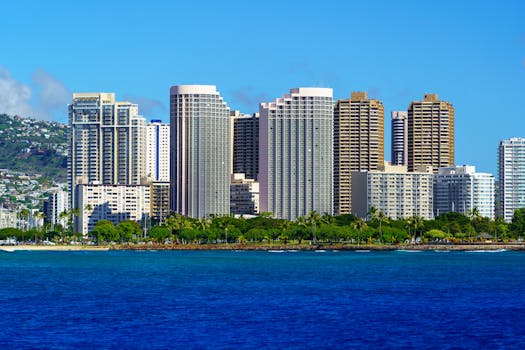 Photo by Cyrill Stunning view of Honolulu's skyline with modern skyscrapers and blue ocean backdrop.