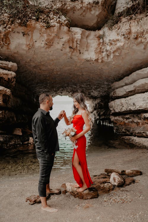 Young Couple in Elegant Clothes Standing on the Shore next to a Cliff 