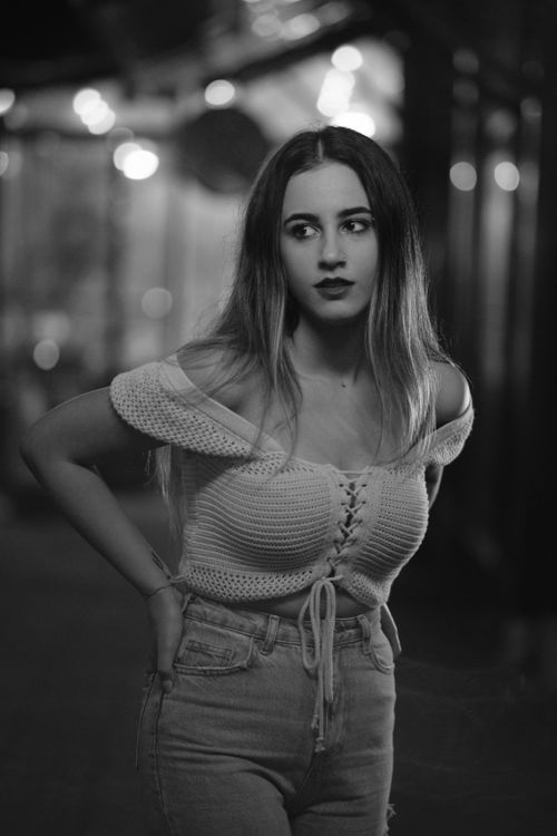 Free Stylish woman posing on city street at night, elegant monochrome portrait. Stock Photo