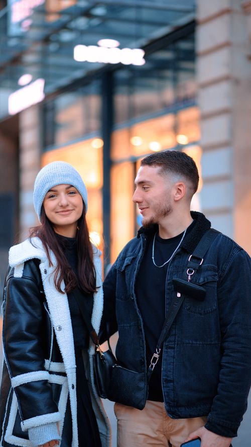 Free Fashionable duo smiling in city setting, showcasing winter style. Stock Photo