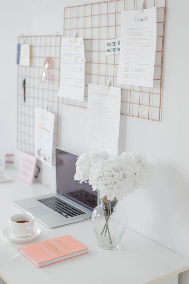 Laptop And Flowers In Vase On Desk 