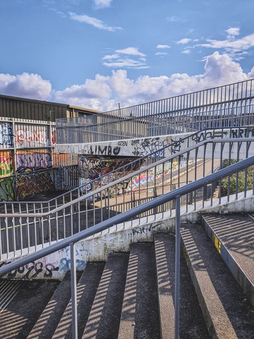 Free Urban footbridge in Bristol with vibrant graffiti, under a bright sky. Stock Photo
