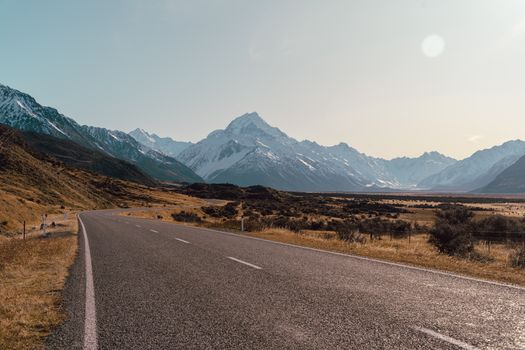 Open road leading to Aoraki Mount Cook, framed by stunning alpine mountains in New Zealand.