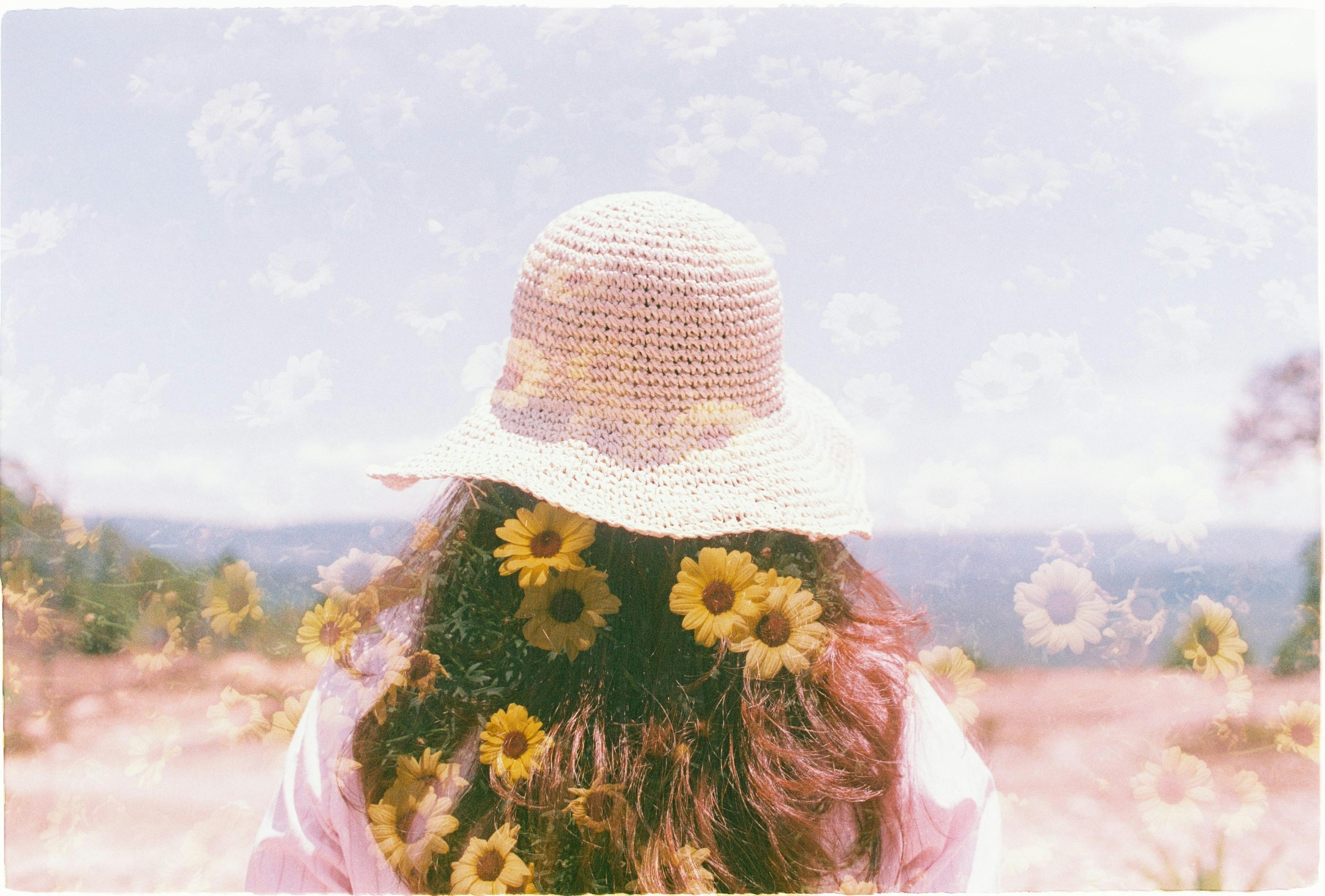 silhouettes of petals over woman in hat