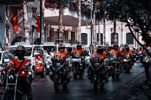 Free Motorcyclists and taxis in a vibrant city street, showcasing urban traffic. Stock Photo