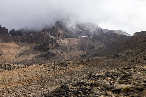 Free A misty mountain range with rocks and fog creating a dramatic landscape view. Stock Photo