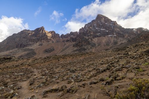 Free A stunning view of a rugged mountain landscape with rocky terrain under a vibrant blue sky. Stock Photo