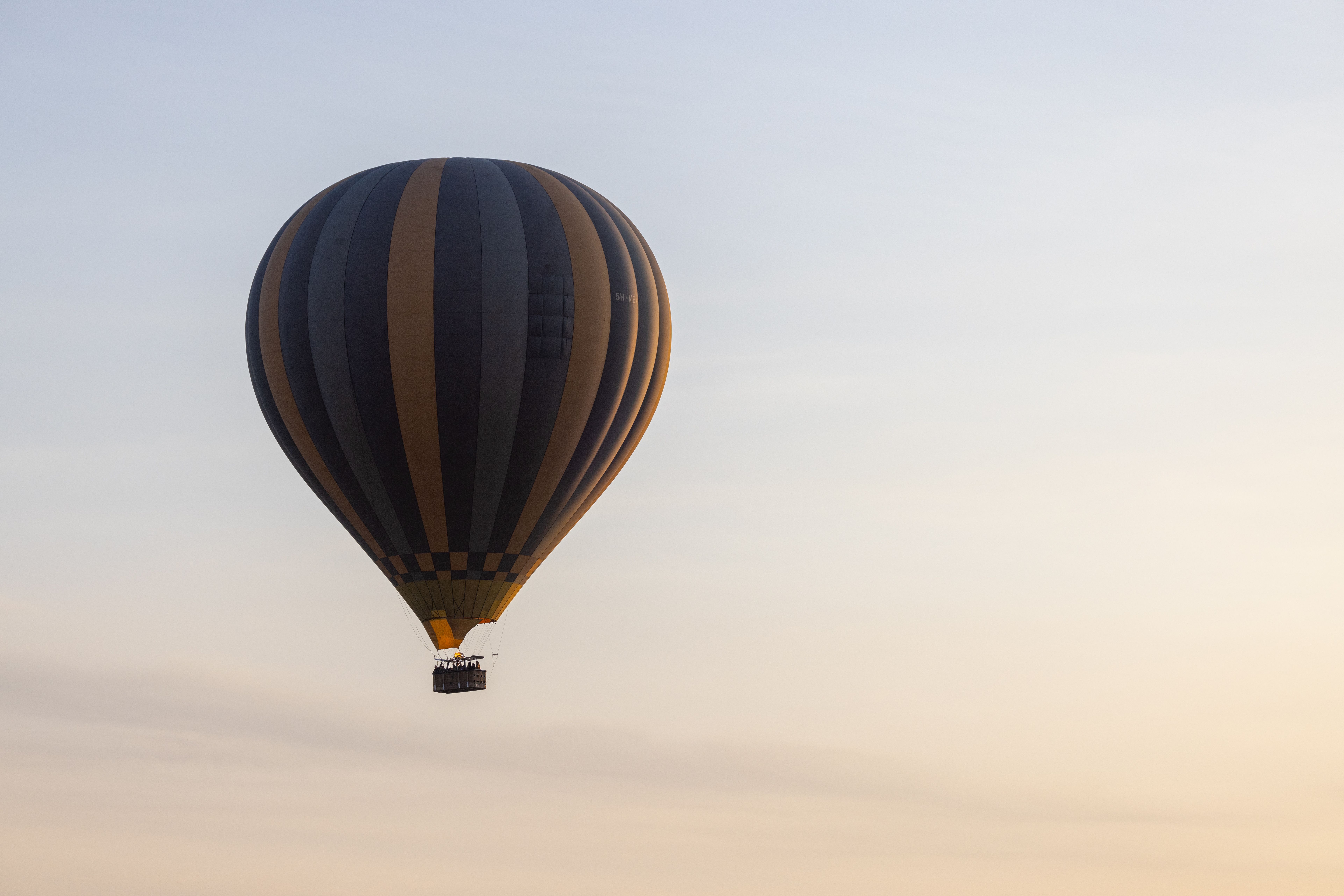A calm journey in a hot air balloon during a beautiful sunrise, with a clear sky backdrop. A calm journey in a hot air balloon during a beautiful sunrise, with a clear sky backdrop.