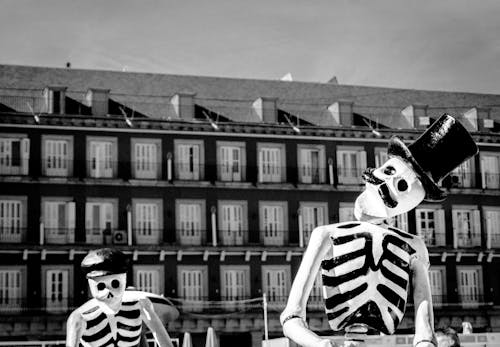 Monochrome Photo of Two Skeleton Wearing Hats