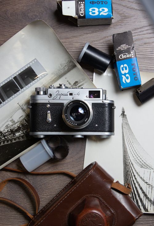 Free Classic Zorki 4 camera with film rolls and printed photos, embodying retro photography. Stock Photo