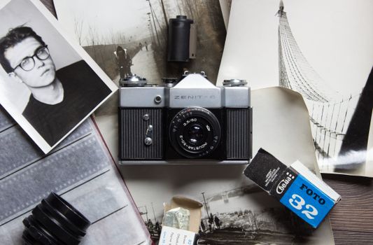 Classic Zenit-8 camera surrounded by vintage photographs and 35mm film, capturing the essence of analog photography.