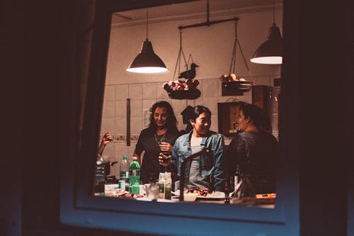 Three Women Standing Inside Room With Lights Turned on