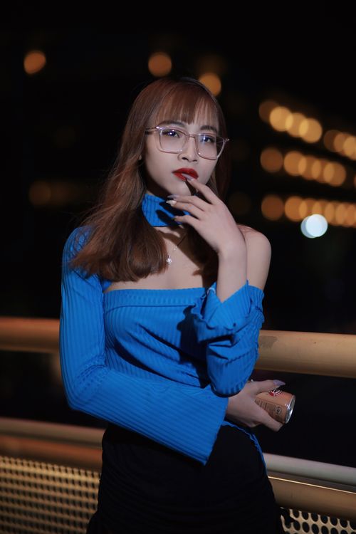 Free Elegant woman in blue top posing at night with artistic bokeh lights. Stock Photo