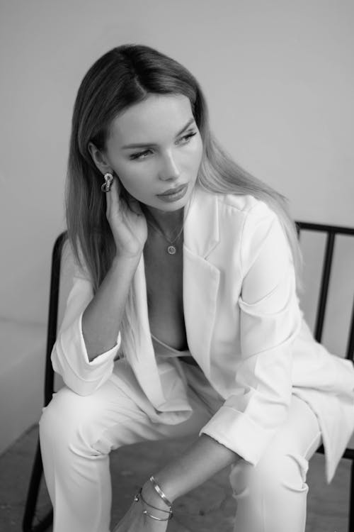 Young Elegant Woman in a White Suit Posing in Studio 