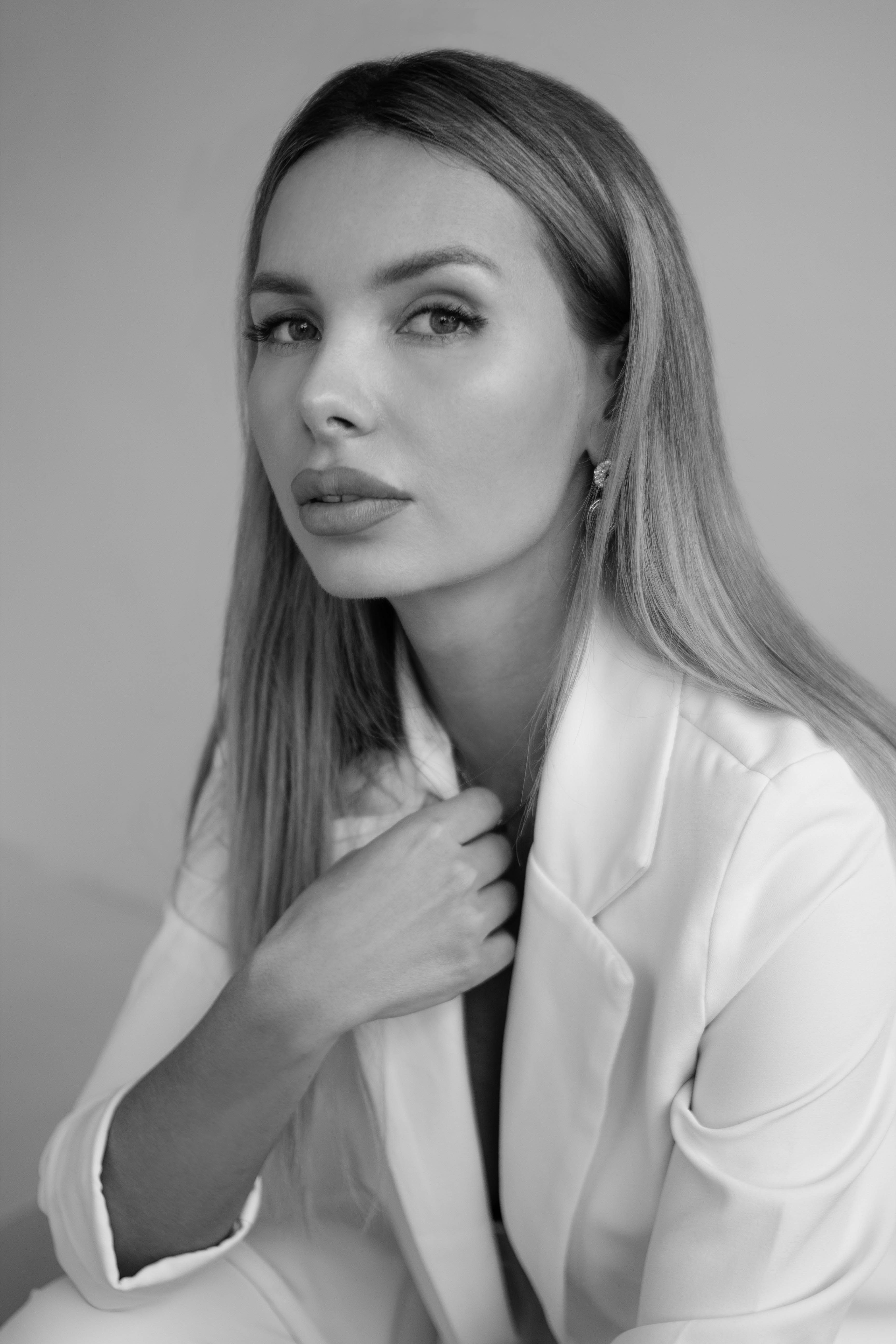 Young Elegant Woman in a White Suit Posing in Studio · Free Stock Photo