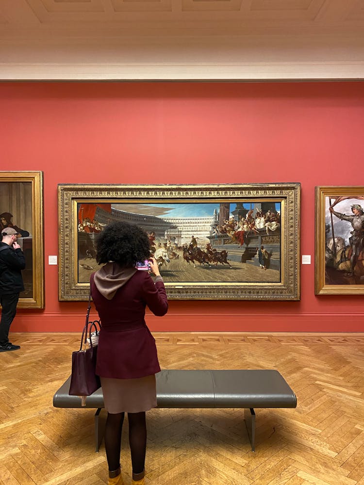 Woman Looking At Paintings In A Museum 