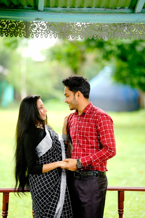 Young Couple in Traditional Clothing in a Park 