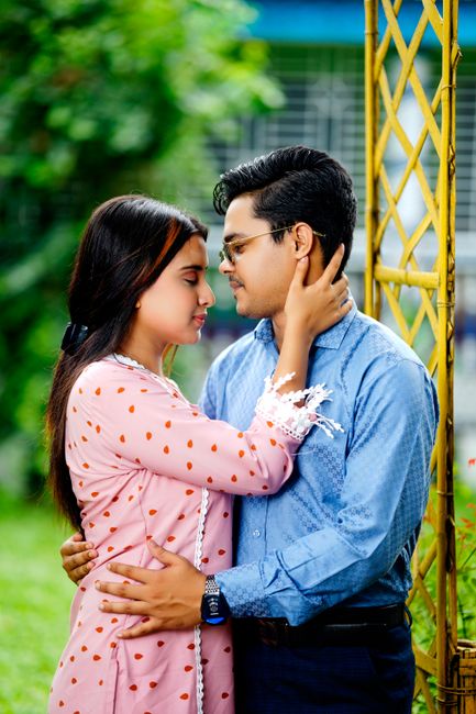 Fotomural Una joven pareja comparte un tierno abrazo en un entorno verde y exuberante de parque, exudando amor y afecto.