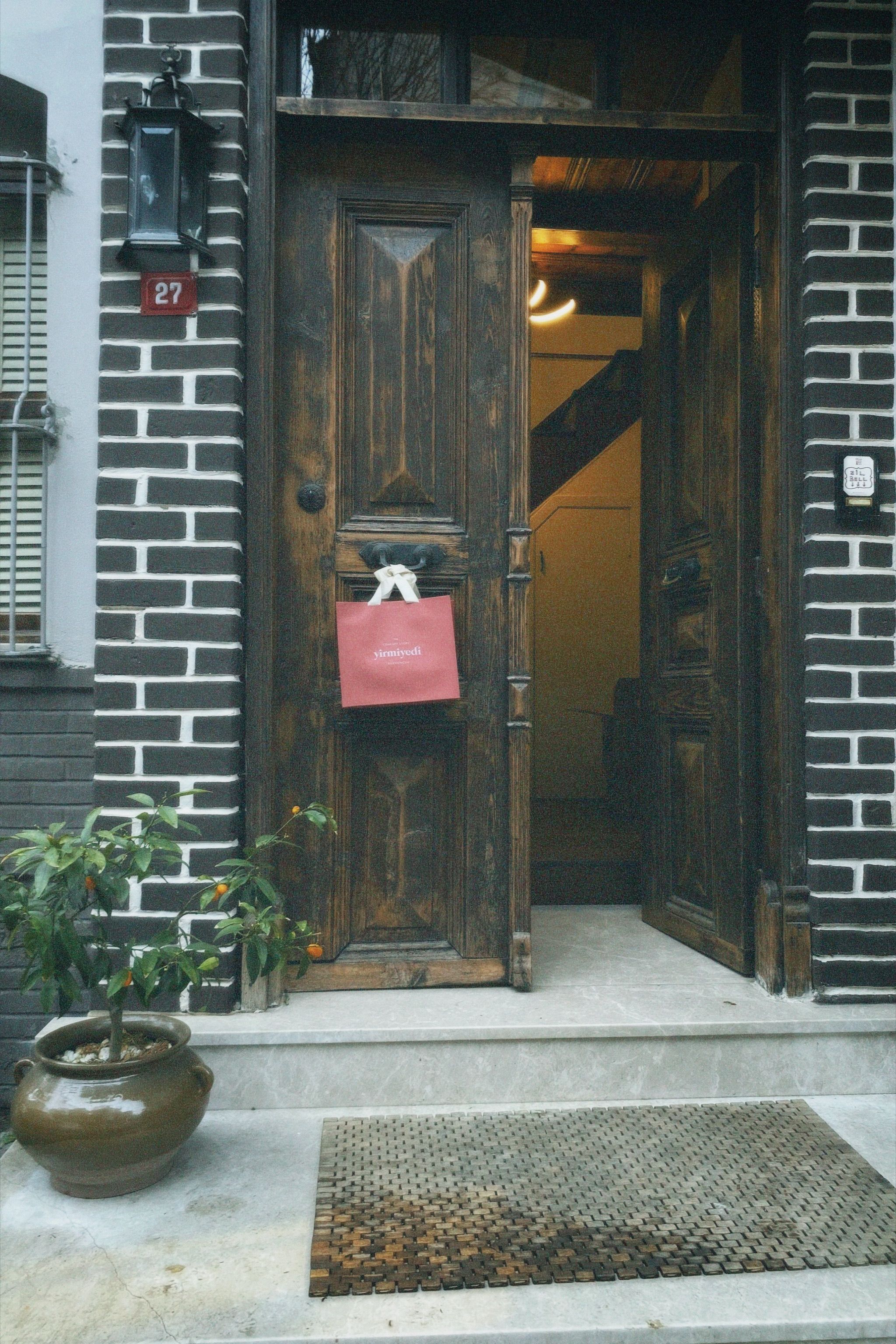Charming rustic wooden doorway with open door and welcoming potted plant, perfect for urban or architectural themes.