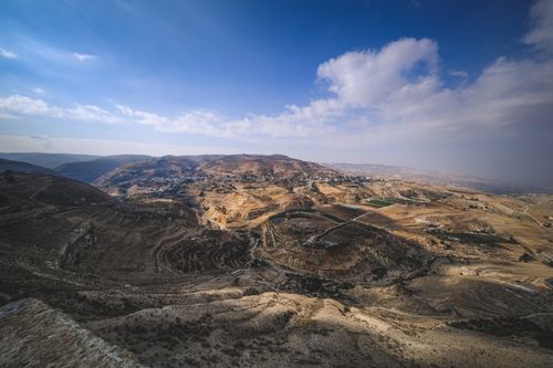 Free Explore a vast arid desert landscape with rugged mountains under a striking blue sky. Stock Photo