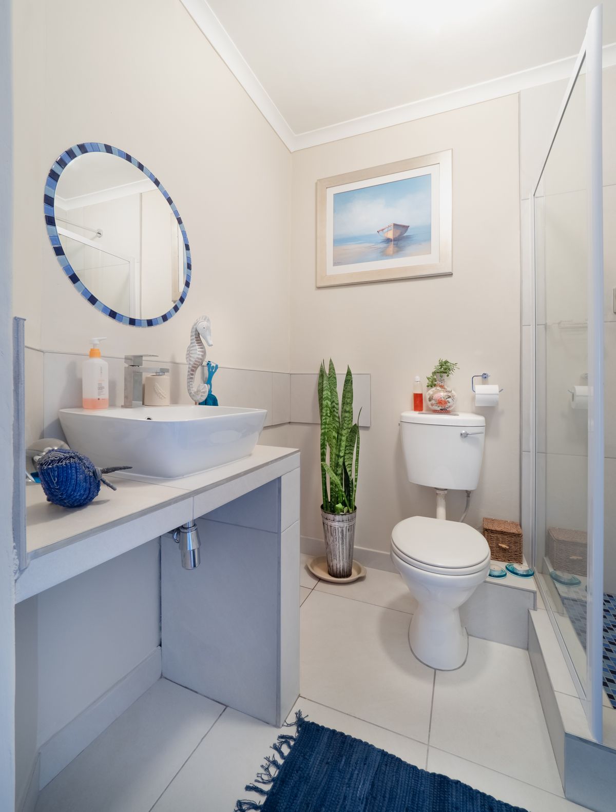 White ceramic toilet bowl beside a glass shower wall in a modern bathroom