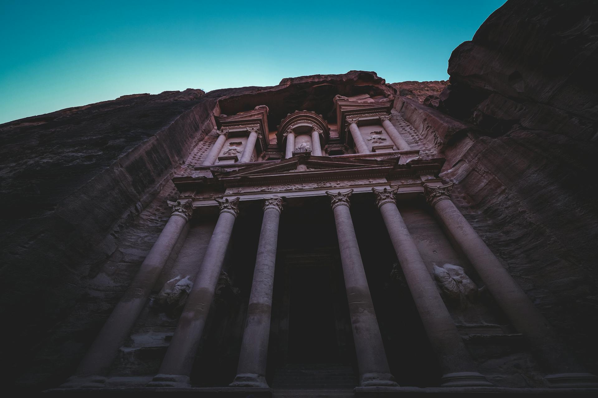 Majestic view of the ancient Petra Treasury landmark against the early morning sky.