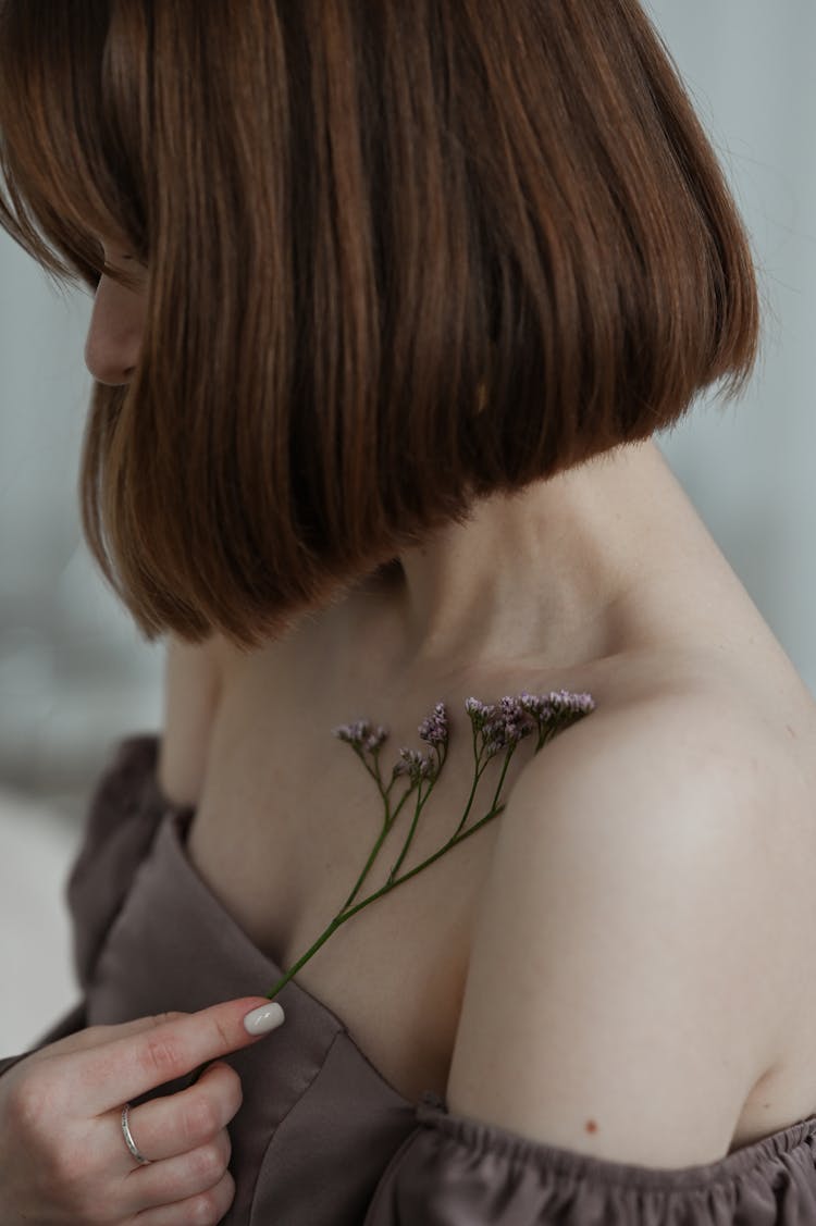 Woman Holding Flower Over Skin