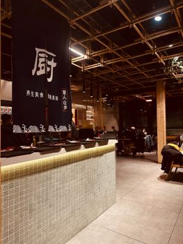 Explore the warm ambiance of a modern Japanese restaurant with cultural decor and open seating.