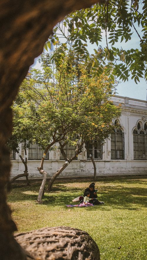 Free A peaceful scene of a mother and daughter enjoying leisure time under trees in a Lima park. Stock Photo