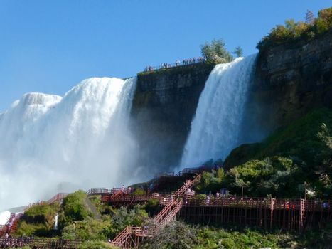 Breathtaking view of Niagara Falls with tourists enjoying the scenic beauty on a sunny day.