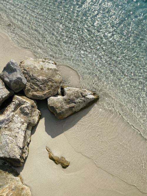 Free Serene beach scene with rocks and clear waters in Göcek, Türkiye. Stock Photo