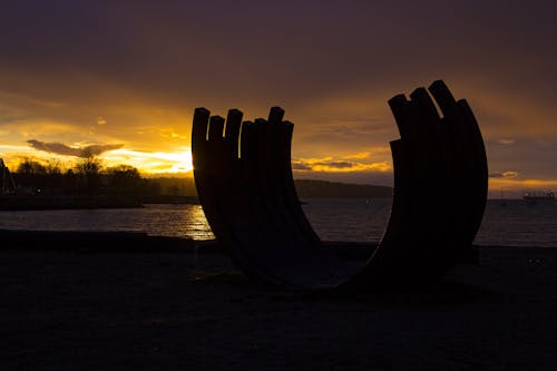 Bezpłatne Zdjęcie Sylwetki Rock Monolith W Pobliżu Oceanu Podczas Złotej Godziny Zdjęcie z galerii