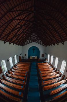 Overhead view of a traditional church interior featuring wooden pews and a cross, ideal for religious themes.