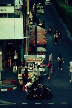 A bustling street in Bangkok featuring vendors and pedestrians, showcasing urban life.
