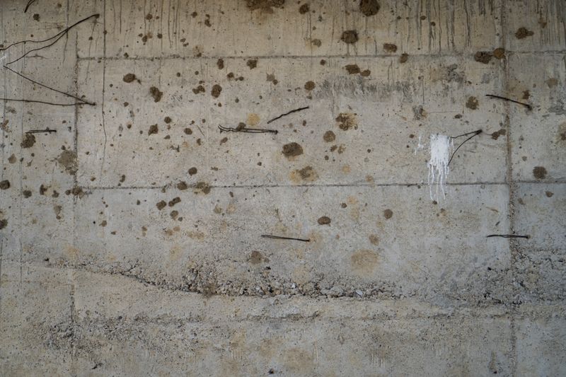 Concrete wall texture with exposed reinforcement