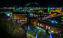夜晚，从空中俯瞰纽卡斯尔码头，桥梁和城市景观的灯光交相辉映