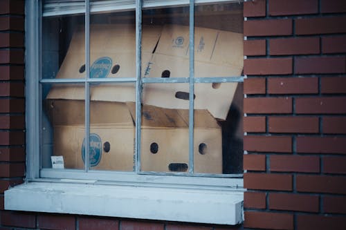 A window with cardboard boxes in it