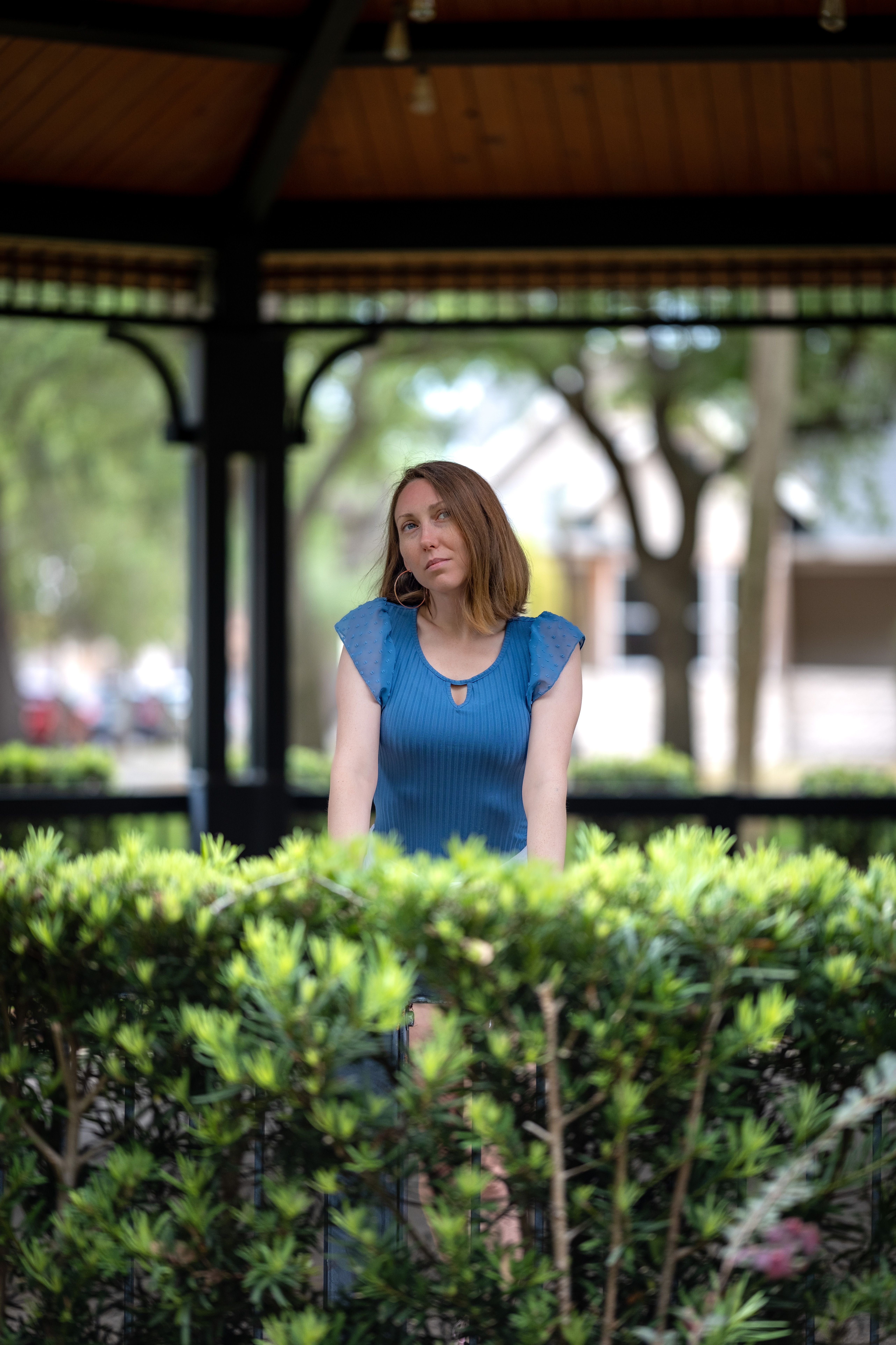 A woman in a blue dress stands in front of a gazebo · Free Stock Photo