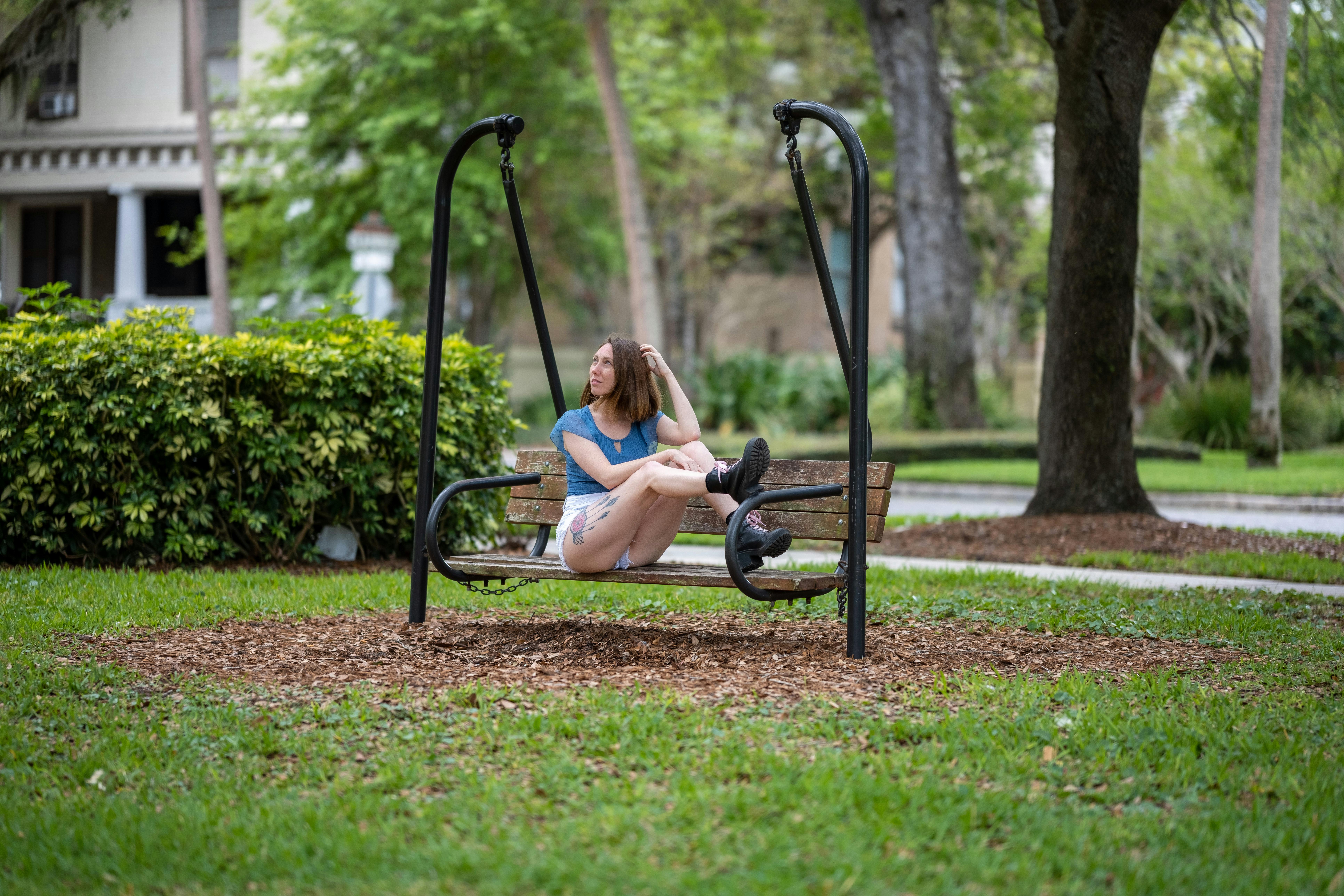 a woman sitting on a swing in a park