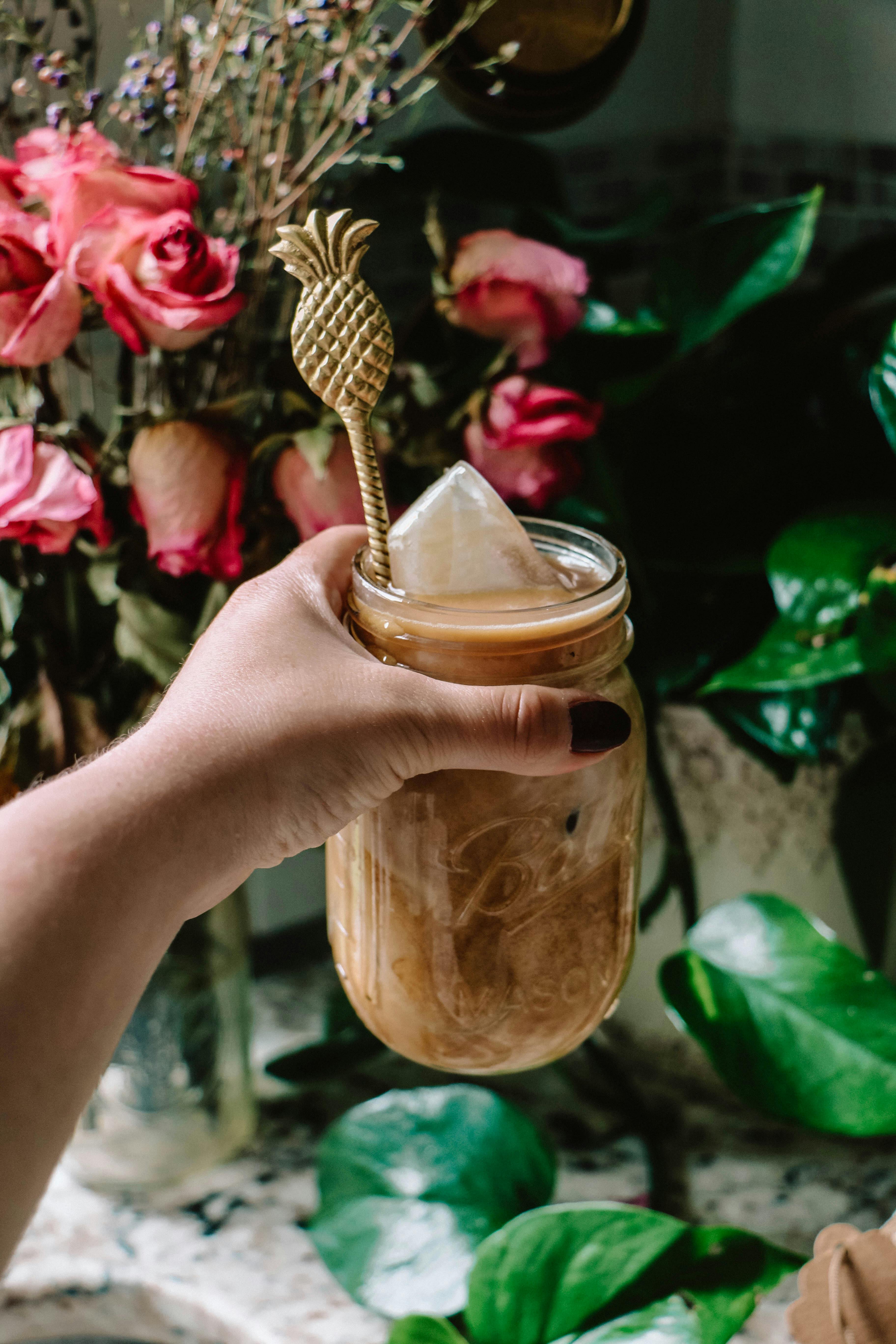 Brown Mason Jar Mug With Straw Beside Plant on Table · Free Stock Photo