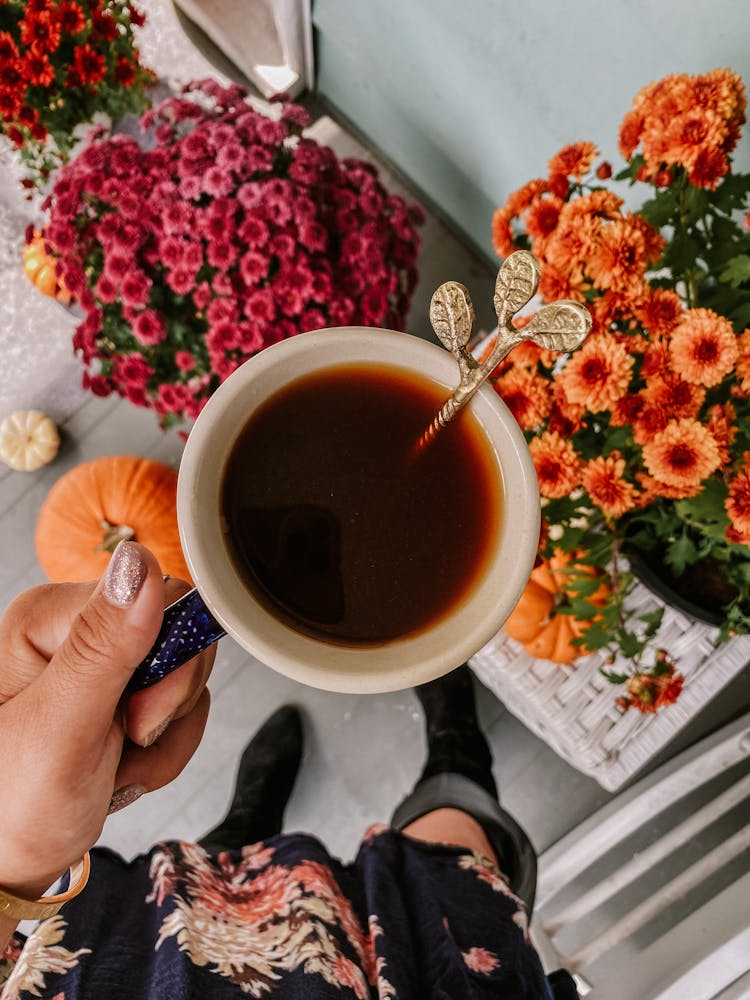 Woman Hand Holding Tea Cup With Decorated Spoon