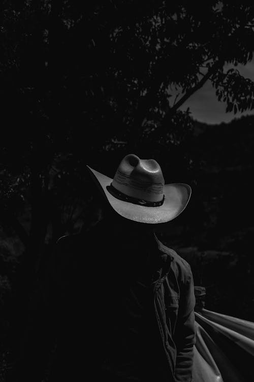 Man with His Face Hidden in the Shadow of the Cowboy Hat Brim