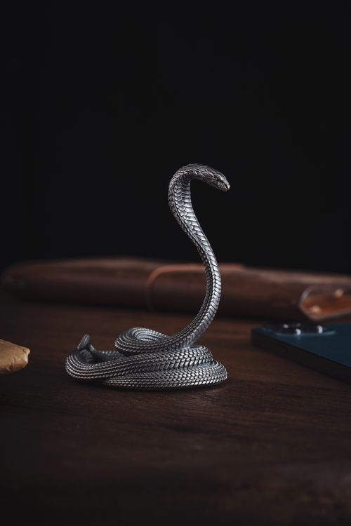 Free Stylish snake-shaped phone stand made of oxidized silver, perfect for decoration. Stock Photo